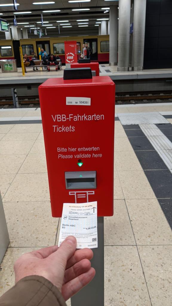 Timbrare il biglietto nella stazione del treno dell'aeroporto di Berlino Timbrare il biglietto nella stazione del treno dell'aeroporto di Berlino