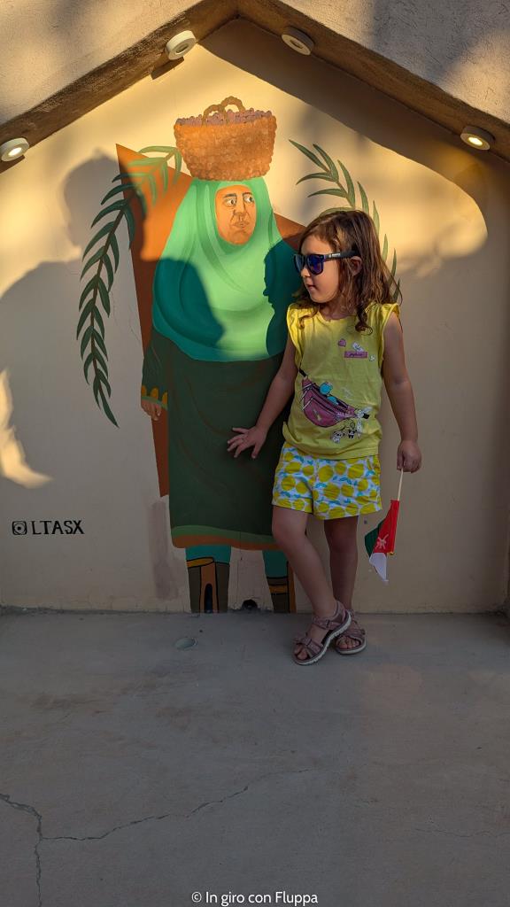 Vicky vicino ad un dipinti sulle antiche mura di Nizwa